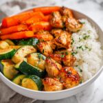 Close-up of a vibrant Chicken Veggie Summer Bowl featuring glazed chicken, zucchini, carrots, and white rice.