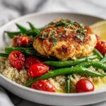 A perfectly seared patty served over quinoa, green beans, and roasted tomatoes, representing an Easy Healthy Summer Dinner.