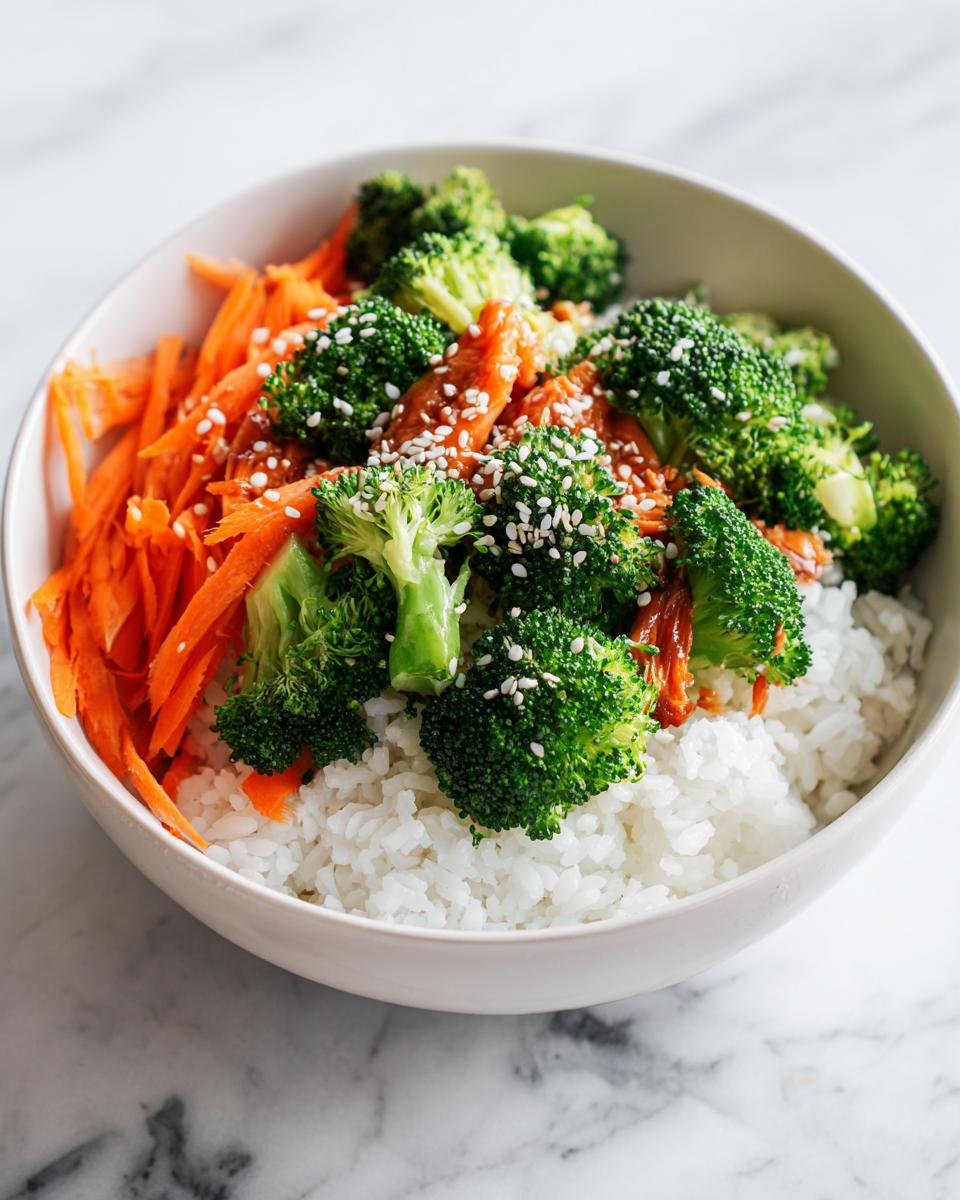 Close-up of an Easy Summer Dinner Bowl featuring white rice topped with bright green broccoli, shredded carrots, and sesame seeds.