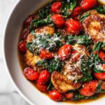 Close-up of pan-seared chicken breasts topped with roasted cherry tomatoes, wilted spinach, and grated Parmesan, perfect for Easy Summer Dinner Recipes Chicken.