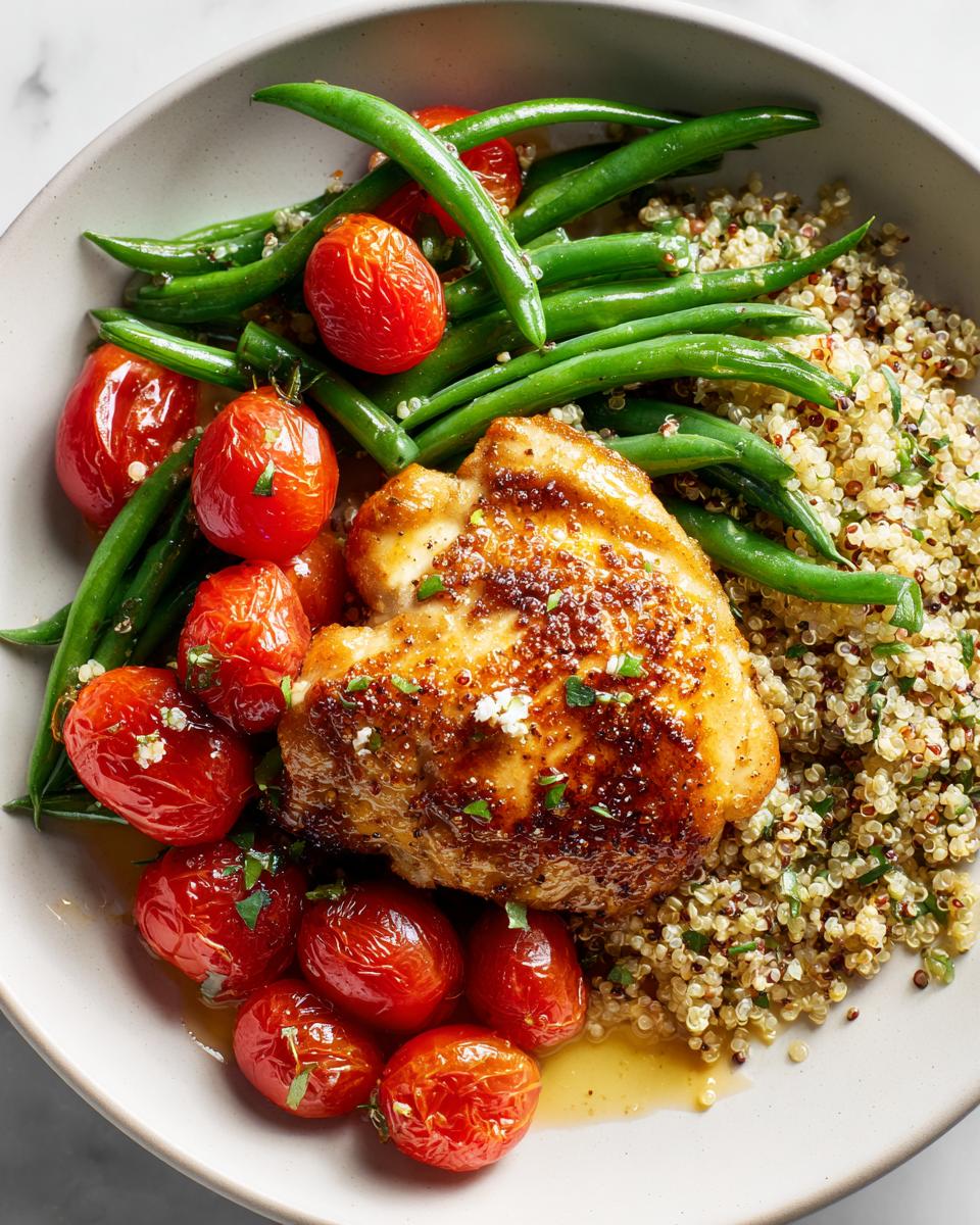 Close-up of a Fresh Summer Chicken Plate featuring a glazed chicken thigh, roasted cherry tomatoes, green beans, and quinoa.