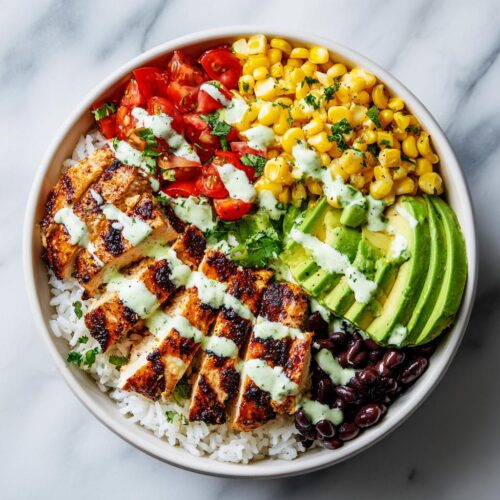 Overhead view of a vibrant Fresh Summer Taco Bowl featuring grilled chicken, rice, corn, tomatoes, avocado, and a creamy green drizzle.