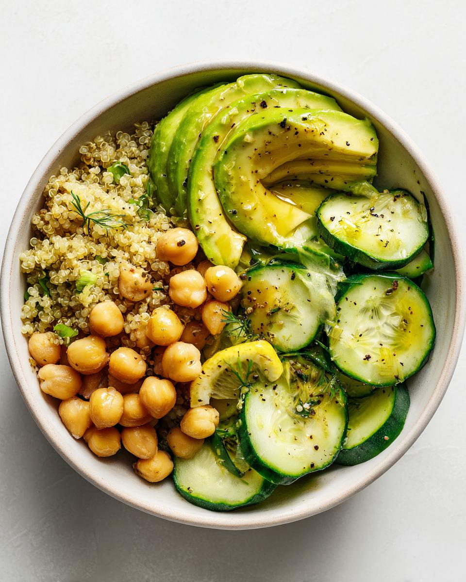 Overhead view of a Healthy Summer Lunch Bowl featuring quinoa, chickpeas, sliced avocado, and cucumber.