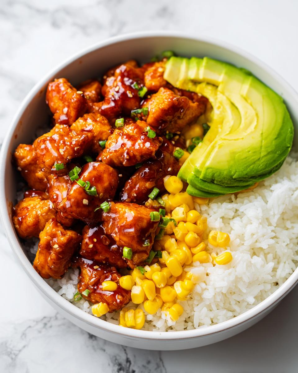Close-up of a Honey Lime Chicken Summer Bowl featuring glazed chicken pieces, white rice, corn, and sliced avocado.