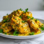 Close-up of glistening Lemon Garlic Chicken Summer pieces coated in a bright yellow sauce and garnished with fresh parsley.