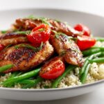 Seared chicken breast strips served over quinoa, green beans, and cherry tomatoes for a Light Chicken Dinner Summer.