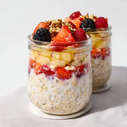Close-up of an Overnight Oats Aesthetic Jar topped with fresh strawberries, blackberries, raspberries, and granola.