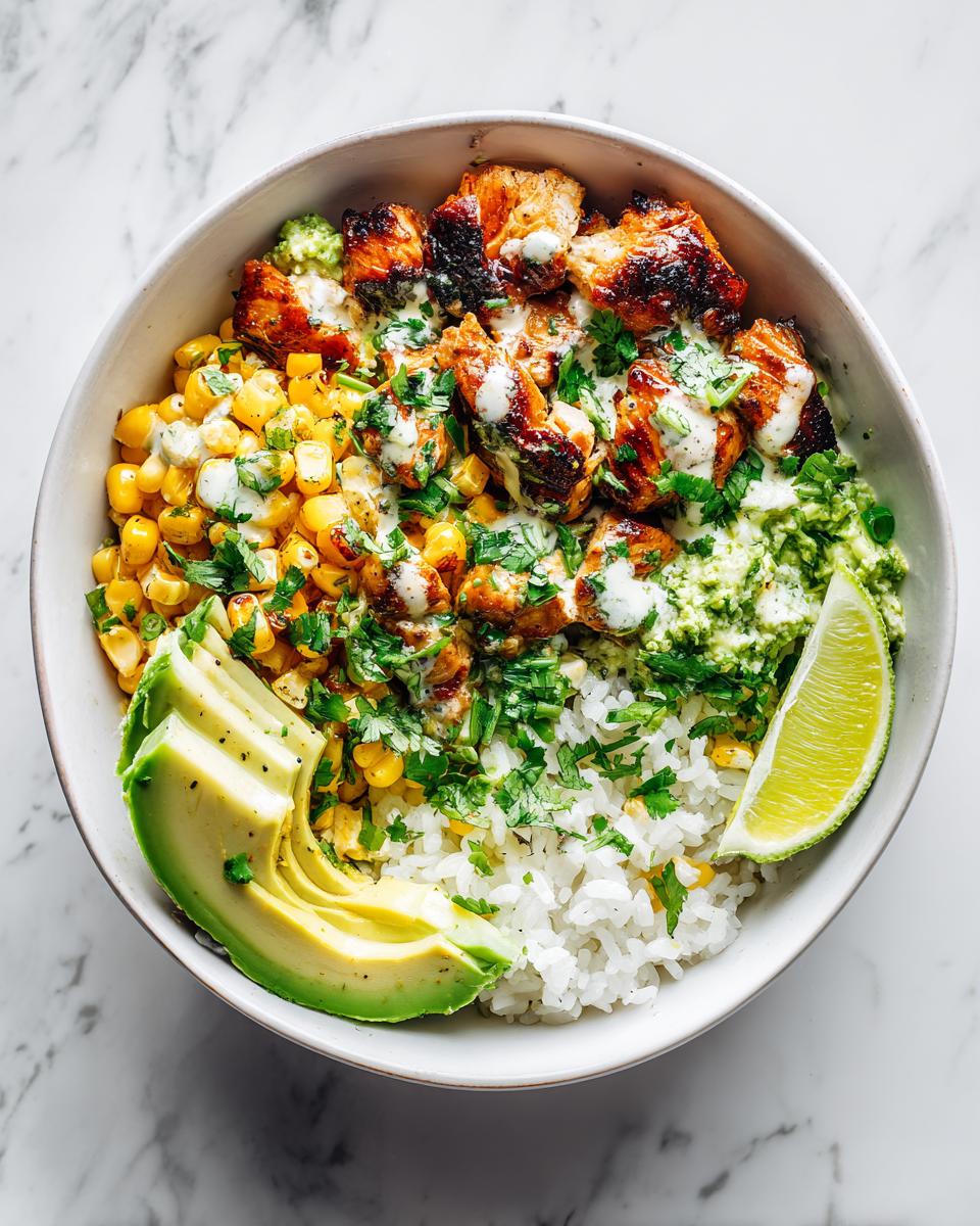 Overhead view of a vibrant Summer Chicken Corn Bowl featuring grilled chicken, corn, rice, avocado, and lime.