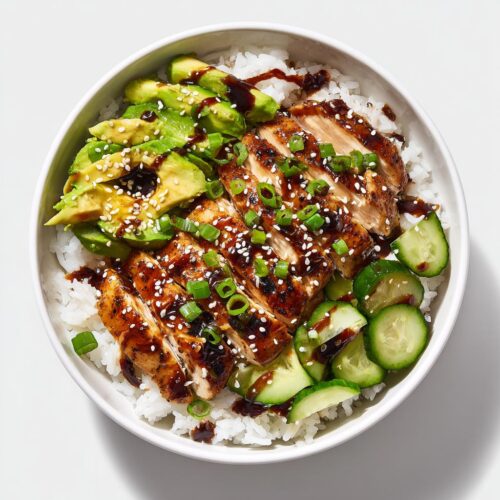Overhead view of a Summer Rice Bowl with Chicken, sliced avocado, cucumbers, and sesame seeds.