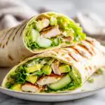A grilled chicken and avocado Wrap Sandwich cut in half, perfect for a quick picnic lunch.