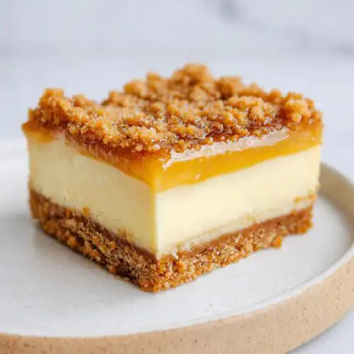 Close-up of a perfect square slice of Cinnamon Cheesecake Crunch Bars on a plate.